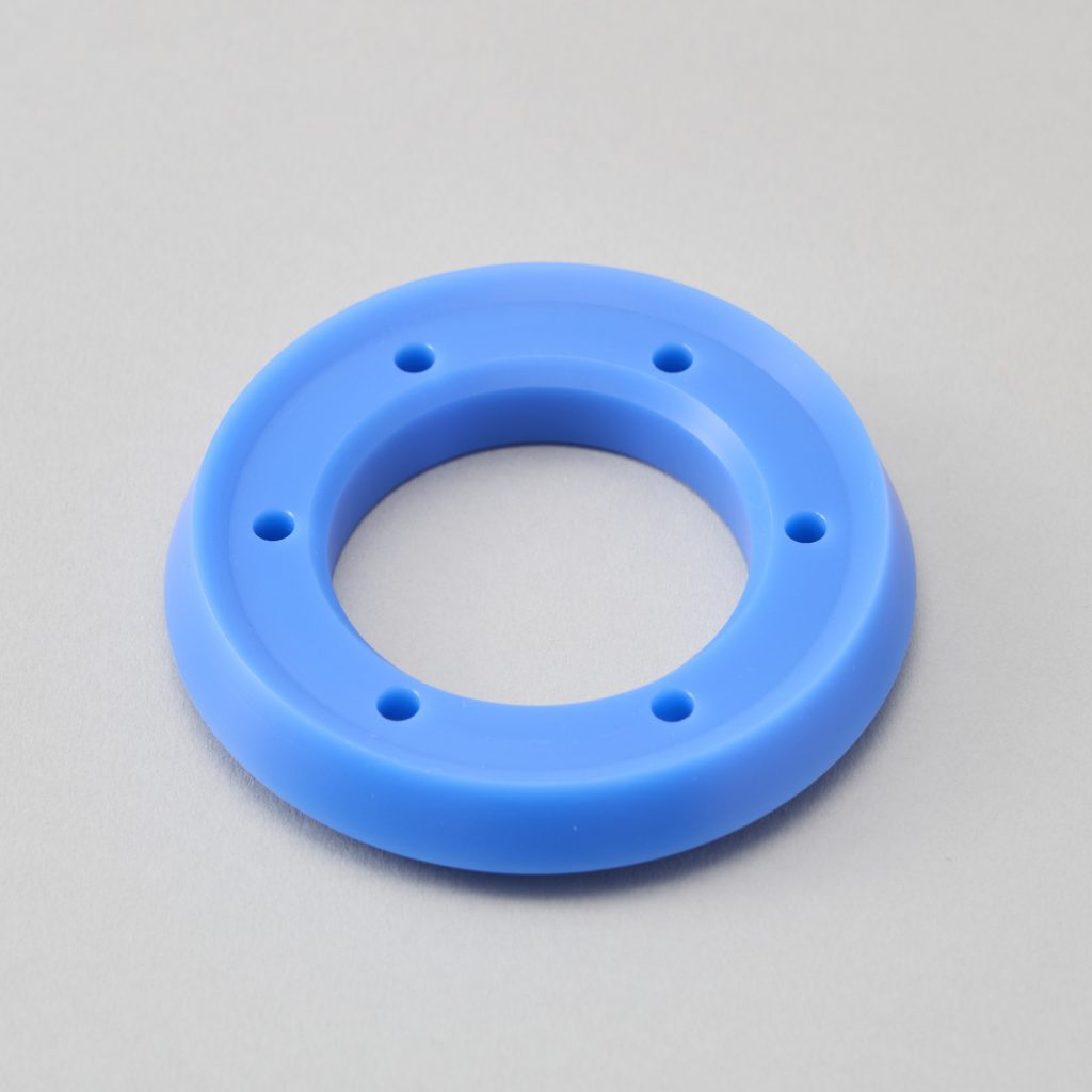 フランジ状の段差がある青色樹脂の円形ブッシュ・リング部品